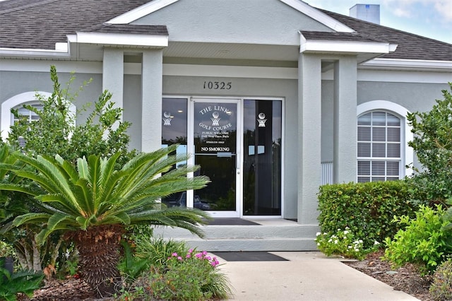 10571 Old Grove Cir, Bradenton, FL 34212 - view of exterior entry with roof with shingles and stucco siding