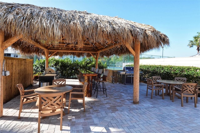 250 Hidden Bay Dr Unit 302, Osprey, FL 34229 - view of patio featuring outdoor dining area, a gazebo, and an outdoor kitchen