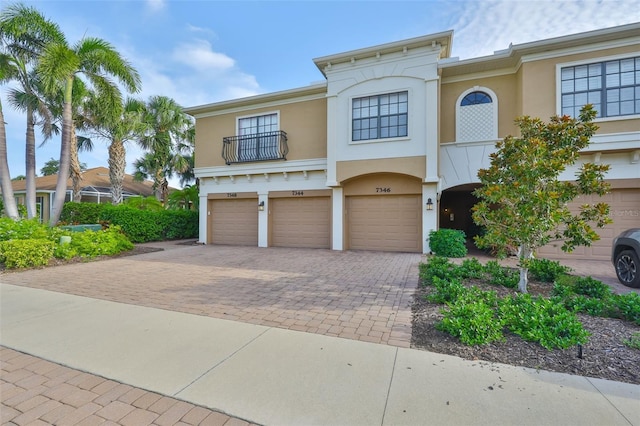 7344 Skybird Rd, Bradenton, FL 34209 - mediterranean / spanish home featuring decorative driveway, stucco siding, an attached garage, and a balcony