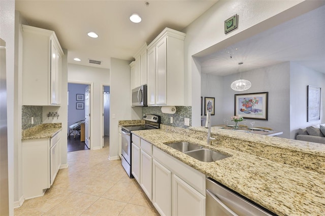 7344 Skybird Rd, Bradenton, FL 34209 - kitchen with stainless steel appliances, tasteful backsplash, recessed lighting, light tile patterned flooring, and white cabinets