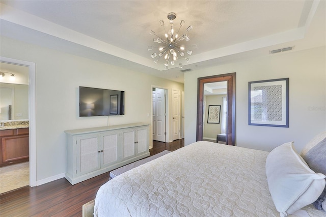 7344 Skybird Rd, Bradenton, FL 34209 - bedroom with a chandelier, dark wood-style floors, a tray ceiling, and connected bathroom