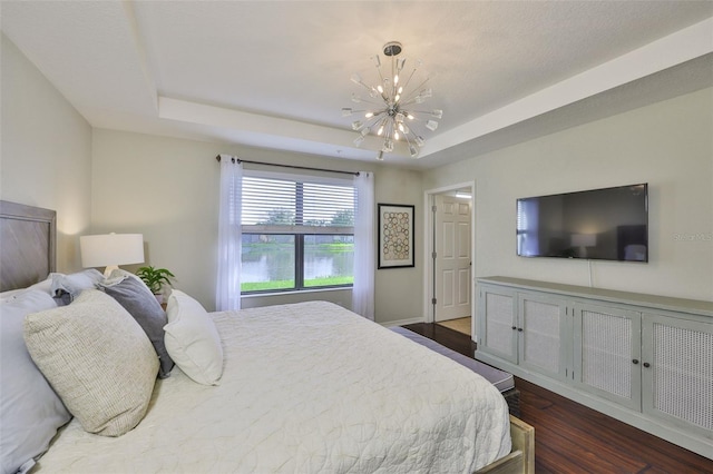 7344 Skybird Rd, Bradenton, FL 34209 - bedroom featuring a chandelier, a tray ceiling, and dark wood finished floors