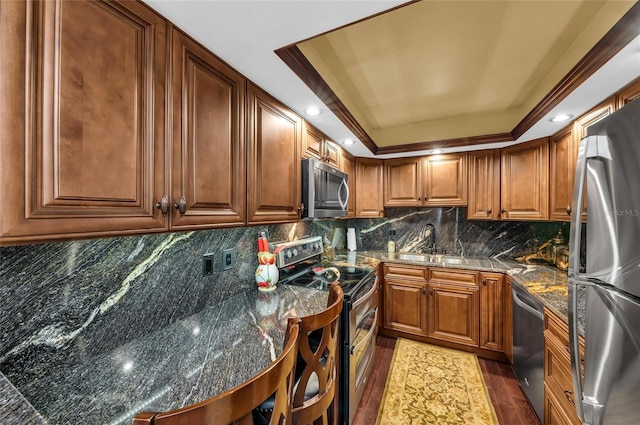 5855 Midnight Pass Rd Unit 416, Sarasota, FL 34242 - kitchen with appliances with stainless steel finishes, a raised ceiling, wood finished floors, brown cabinets, and recessed lighting
