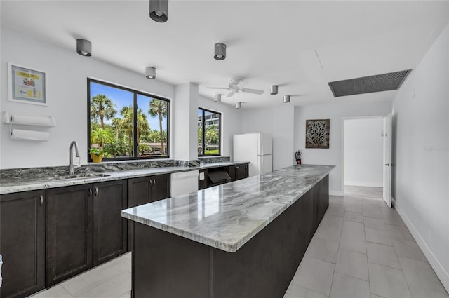 5855 Midnight Pass Rd Unit 416, Sarasota, FL 34242 - kitchen with white appliances, light stone countertops, ceiling fan, light tile patterned floors, and a kitchen island