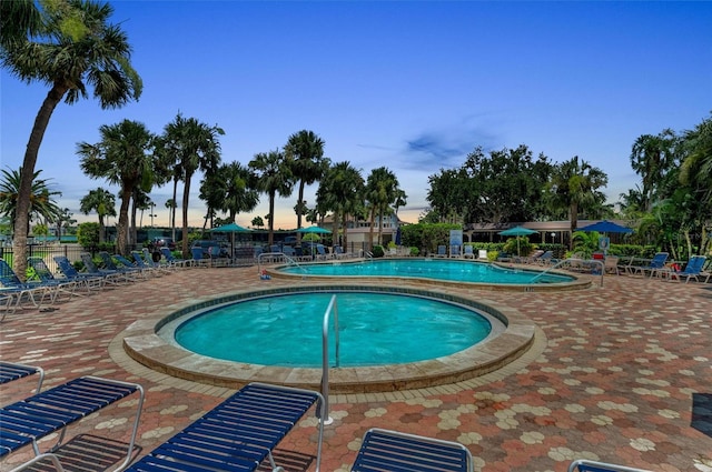 5855 Midnight Pass Rd Unit 416, Sarasota, FL 34242 - pool at dusk featuring a community pool and a patio