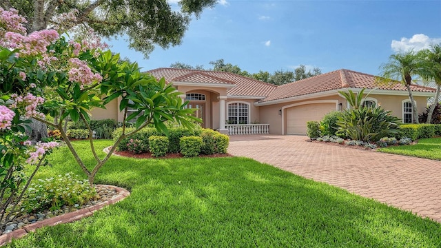 6206 Stillwater Ct, University Park, FL 34201 - mediterranean / spanish home with a garage, stucco siding, a tiled roof, decorative driveway, and a front yard