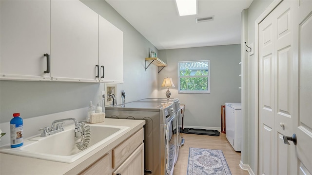 6206 Stillwater Ct, University Park, FL 34201 - laundry area with washing machine and clothes dryer, cabinet space, and light wood finished floors