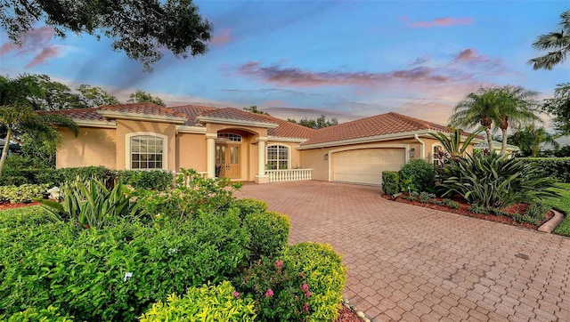 6206 Stillwater Ct, University Park, FL 34201 - mediterranean / spanish-style home featuring a garage, decorative driveway, stucco siding, and a tile roof