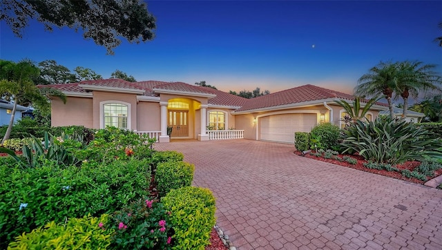 6206 Stillwater Ct, University Park, FL 34201 - mediterranean / spanish home featuring a garage, stucco siding, decorative driveway, and a tile roof