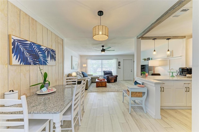 237 Saxon Cir, Venice, FL 34293 - kitchen featuring ceiling fan, light wood-style flooring, a breakfast bar area, hanging light fixtures, and open floor plan
