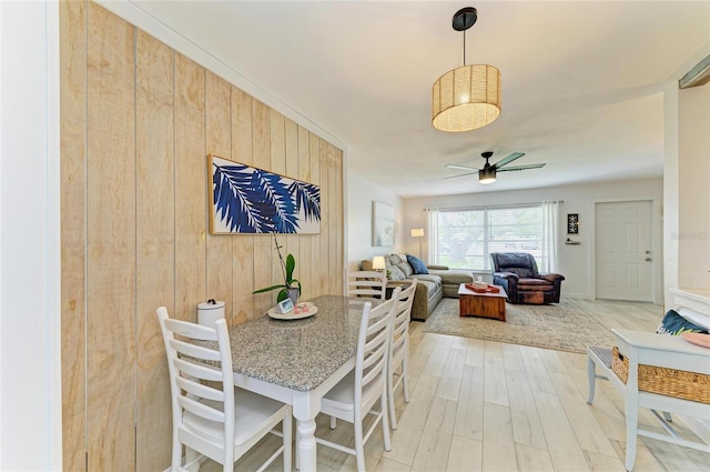 237 Saxon Cir, Venice, FL 34293 - dining room featuring light wood-style flooring, ceiling fan, and wood walls