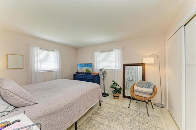 237 Saxon Cir, Venice, FL 34293 - bedroom featuring multiple windows, a closet, and light wood-style flooring