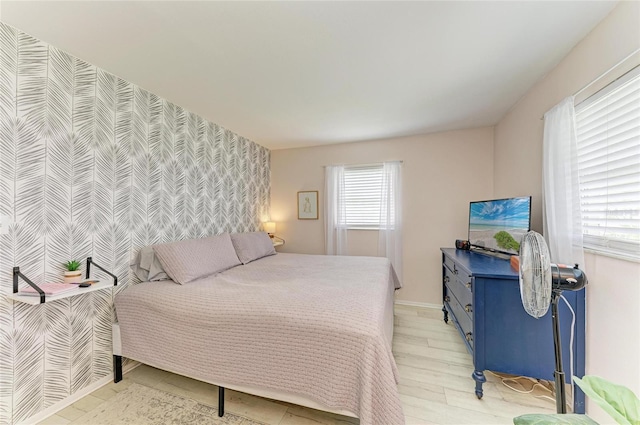 237 Saxon Cir, Venice, FL 34293 - bedroom with an accent wall, wallpapered walls, and light wood-style floors