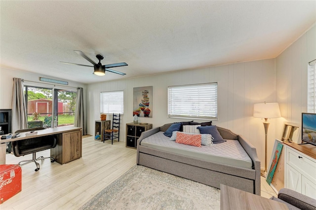 237 Saxon Cir, Venice, FL 34293 - bedroom with multiple windows, light wood-type flooring, a textured ceiling, an office area, and ceiling fan