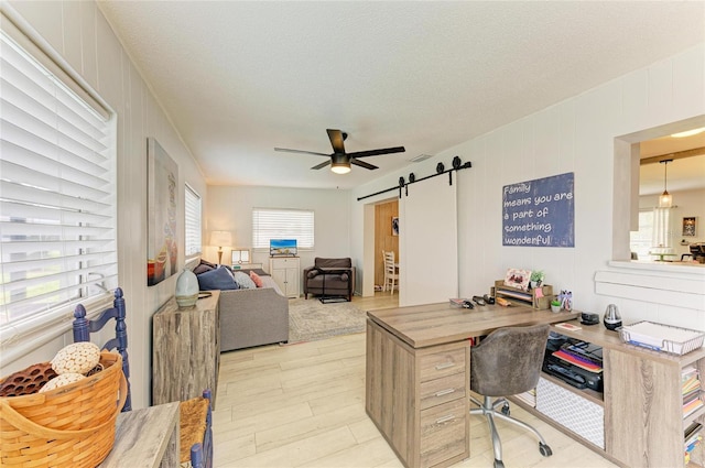 237 Saxon Cir, Venice, FL 34293 - office space with a barn door, ceiling fan, light wood-type flooring, and a textured ceiling
