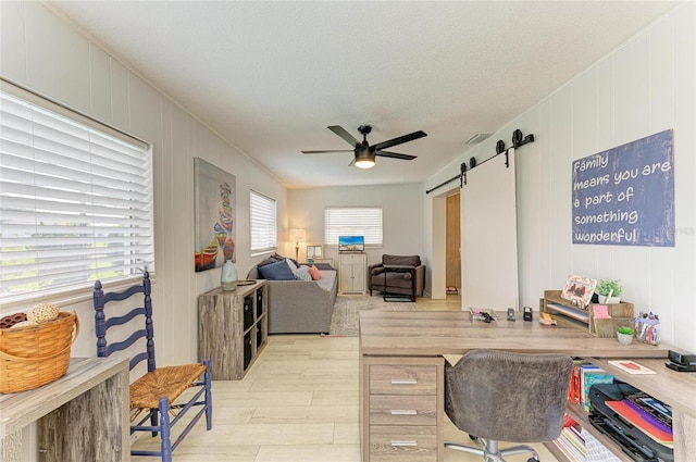 237 Saxon Cir, Venice, FL 34293 - home office featuring ceiling fan, light wood-style floors, a barn door, and a decorative wall