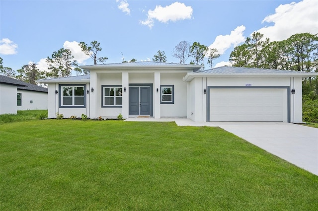 2523 Hagerick Ln, North Port, FL 34288 - view of front of house featuring a garage, concrete driveway, a front lawn, a standing seam roof, and stucco siding