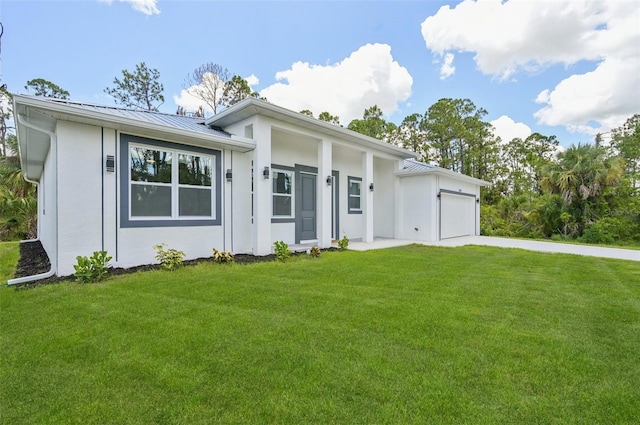 2523 Hagerick Ln, North Port, FL 34288 - view of front of home with an attached garage, a standing seam roof, a front lawn, and stucco siding