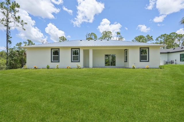 2523 Hagerick Ln, North Port, FL 34288 - rear view of house featuring stucco siding, a lawn, and a metal roof