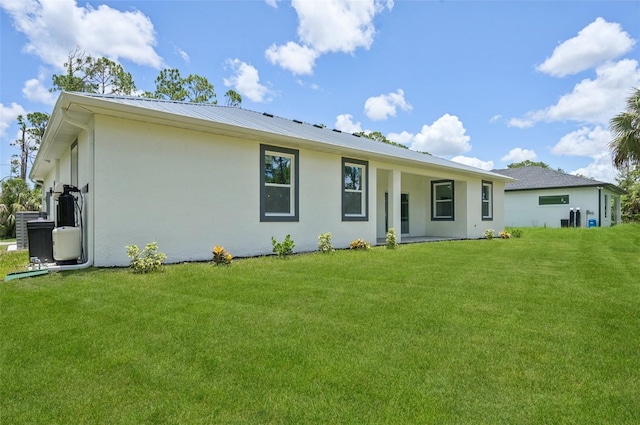 2523 Hagerick Ln, North Port, FL 34288 - back of house with a yard, stucco siding, and a metal roof