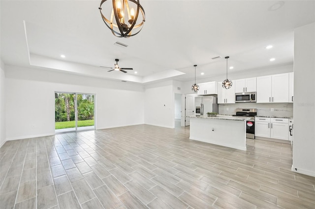 2523 Hagerick Ln, North Port, FL 34288 - unfurnished living room with recessed lighting, a raised ceiling, a chandelier, light wood-style flooring, and a ceiling fan