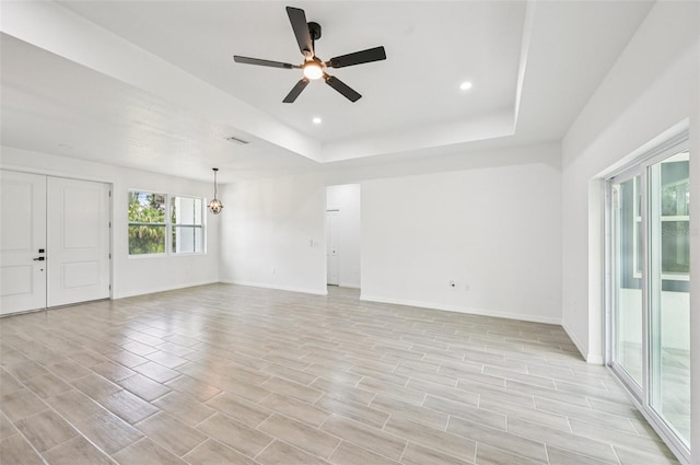 2523 Hagerick Ln, North Port, FL 34288 - unfurnished room featuring a ceiling fan, a chandelier, light wood finished floors, a raised ceiling, and recessed lighting
