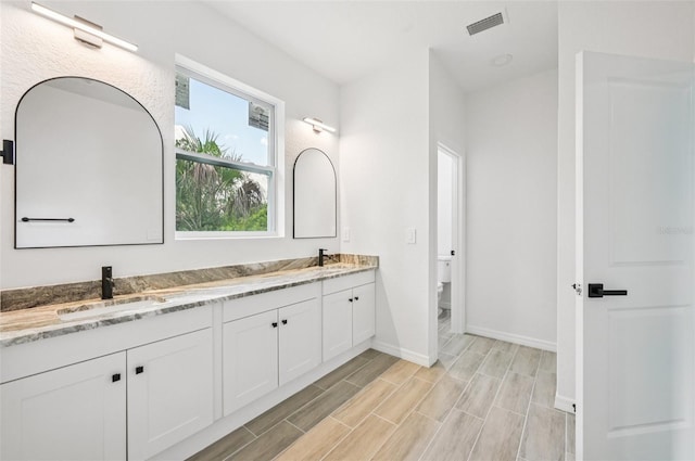 2523 Hagerick Ln, North Port, FL 34288 - bathroom featuring double vanity and wood finished floors