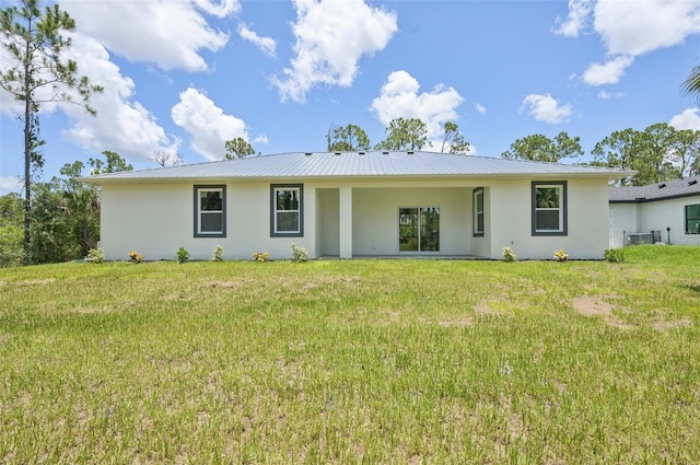 2523 Hagerick Ln, North Port, FL 34288 - rear view of property featuring stucco siding, a lawn, and a metal roof