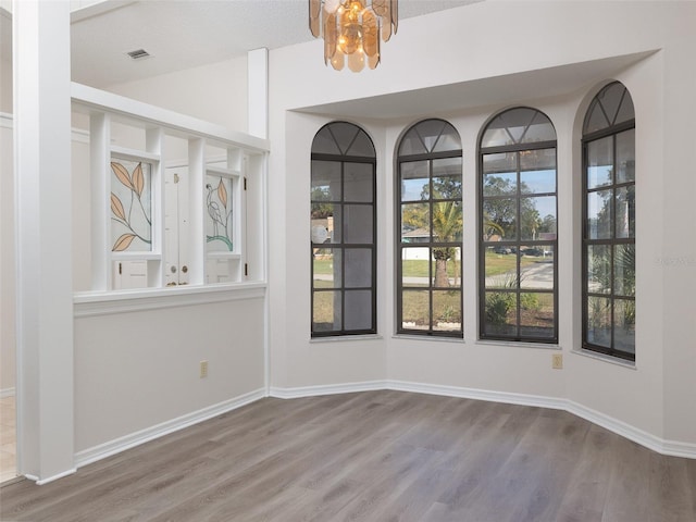 8260 Berkeley Manor Blvd, Spring Hill, FL 34606 - unfurnished dining area featuring wood finished floors, a chandelier, and vaulted ceiling