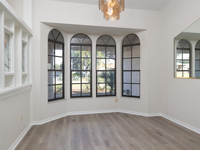 8260 Berkeley Manor Blvd, Spring Hill, FL 34606 - empty room featuring wood finished floors and a chandelier