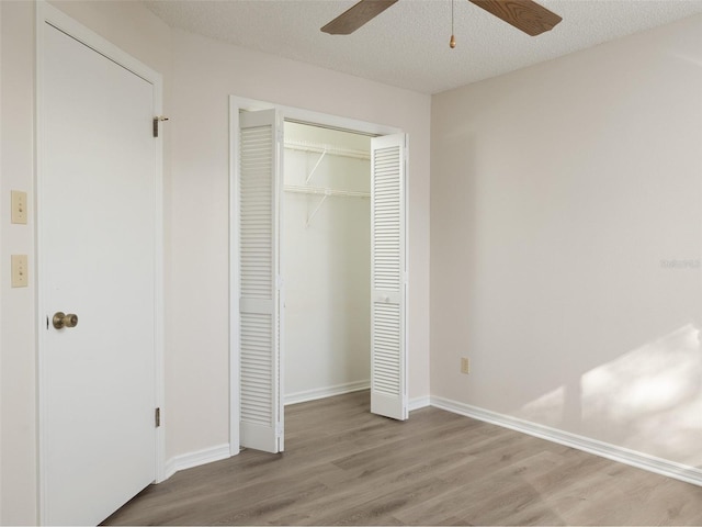 8260 Berkeley Manor Blvd, Spring Hill, FL 34606 - unfurnished bedroom with wood finished floors, a closet, ceiling fan, and a textured ceiling