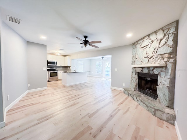 4913 32nd St E, Bradenton, FL 34203 - unfurnished living room with a ceiling fan, light wood finished floors, a fireplace, and recessed lighting