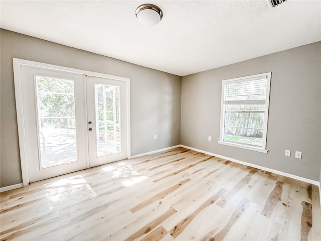 4913 32nd St E, Bradenton, FL 34203 - spare room with french doors, light wood-style flooring, and a textured ceiling