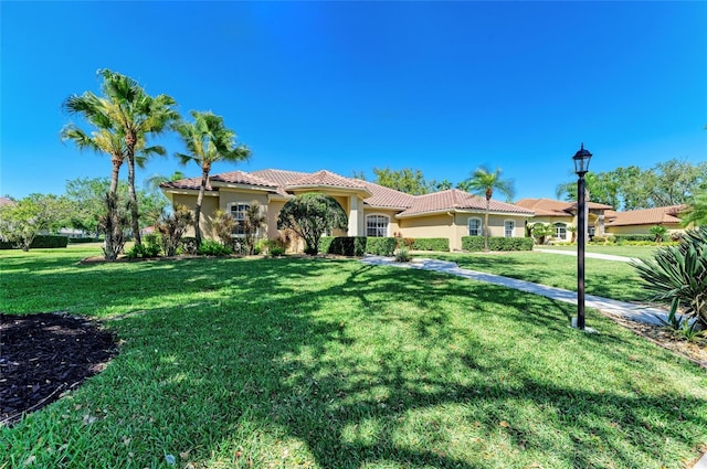 8315 Eagle Xing, Sarasota, FL 34241 - mediterranean / spanish house featuring stucco siding, a front lawn, and a tile roof