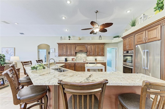 8315 Eagle Xing, Sarasota, FL 34241 - kitchen with appliances with stainless steel finishes, a large island, premium range hood, a breakfast bar, and vaulted ceiling