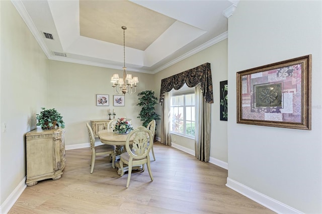 8315 Eagle Xing, Sarasota, FL 34241 - dining area with a chandelier, a raised ceiling, light wood-style flooring, and crown molding