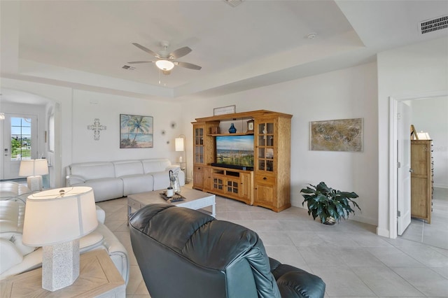 4961 Seafoam Trl, Bradenton, FL 34211 - living area featuring a raised ceiling, ceiling fan, light tile patterned floors, and arched walkways