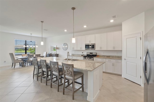 4961 Seafoam Trl, Bradenton, FL 34211 - kitchen featuring stainless steel appliances, white cabinetry, a kitchen island with sink, a kitchen bar, and recessed lighting