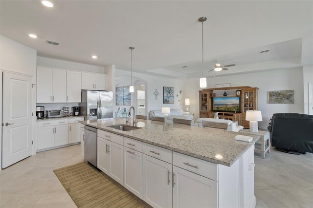4961 Seafoam Trl, Bradenton, FL 34211 - kitchen with appliances with stainless steel finishes, open floor plan, ceiling fan, a kitchen island with sink, and a tray ceiling