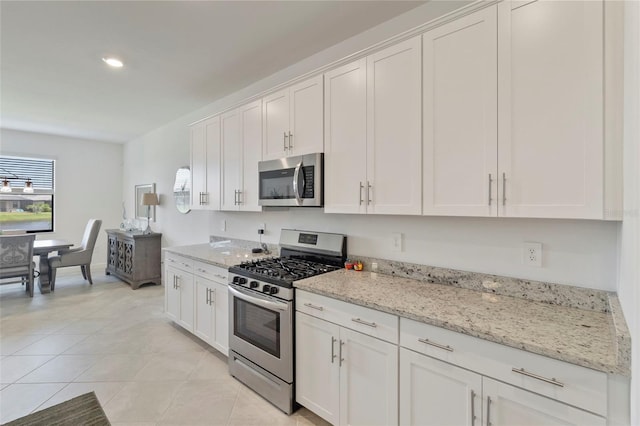 4961 Seafoam Trl, Bradenton, FL 34211 - kitchen featuring appliances with stainless steel finishes, white cabinets, light tile patterned floors, light stone counters, and recessed lighting