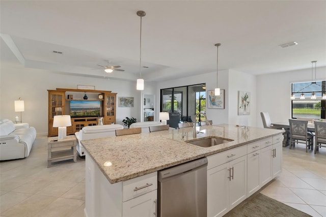 4961 Seafoam Trl, Bradenton, FL 34211 - kitchen featuring stainless steel dishwasher, open floor plan, light tile patterned floors, a kitchen island with sink, and white cabinets