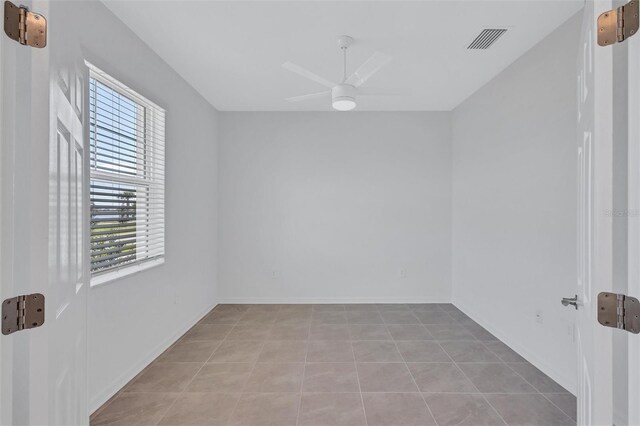 7352 Cabin Ln, Sarasota, FL 34240 - empty room featuring healthy amount of natural light, a ceiling fan, and light tile patterned floors