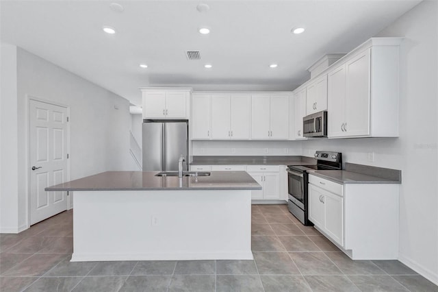 7352 Cabin Ln, Sarasota, FL 34240 - kitchen featuring appliances with stainless steel finishes, a center island with sink, white cabinetry, recessed lighting, and dark countertops