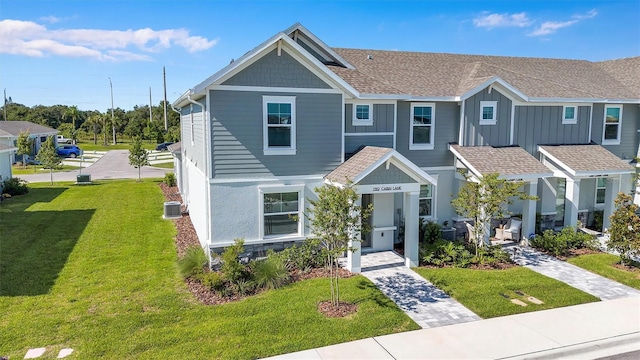 7352 Cabin Ln, Sarasota, FL 34240 - townhome / multi-family property with a front yard and a shingled roof