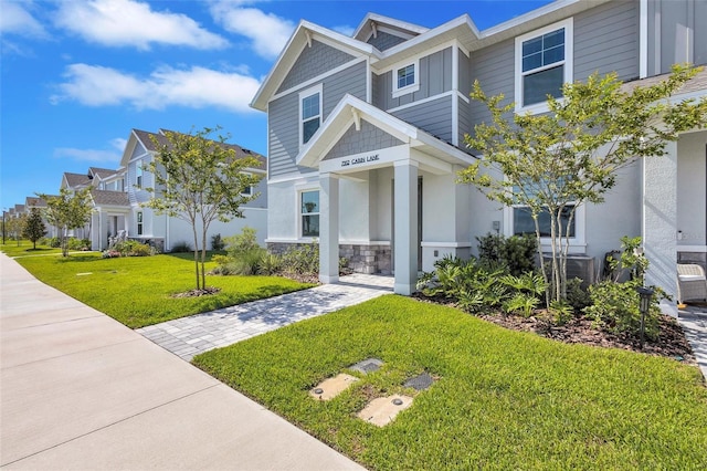 7352 Cabin Ln, Sarasota, FL 34240 - craftsman house featuring a front yard, stone siding, and a residential view