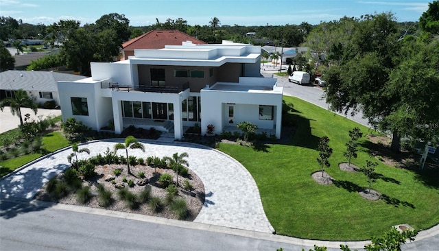 2110 Michele Dr, Sarasota, FL 34231 - rear view of property featuring a balcony, a lawn, stucco siding, and curved driveway