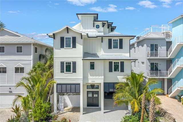 646 Calle Del Otono, Sarasota, FL 34242 - rear view of property with a standing seam roof, board and batten siding, driveway, a carport, and a metal roof