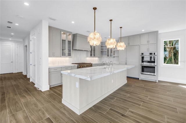 646 Calle Del Otono, Sarasota, FL 34242 - kitchen featuring custom exhaust hood, gray cabinetry, appliances with stainless steel finishes, wood finished floors, and recessed lighting