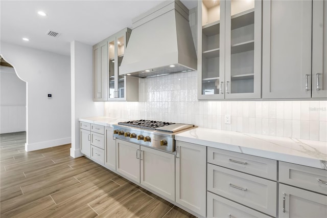 646 Calle Del Otono, Sarasota, FL 34242 - kitchen with custom range hood, stainless steel gas cooktop, light wood-type flooring, decorative backsplash, and recessed lighting