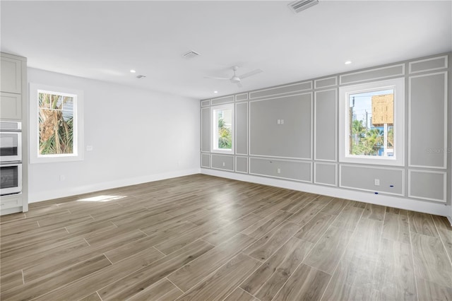 646 Calle Del Otono, Sarasota, FL 34242 - unfurnished living room with a decorative wall, light wood-style floors, healthy amount of natural light, a ceiling fan, and recessed lighting